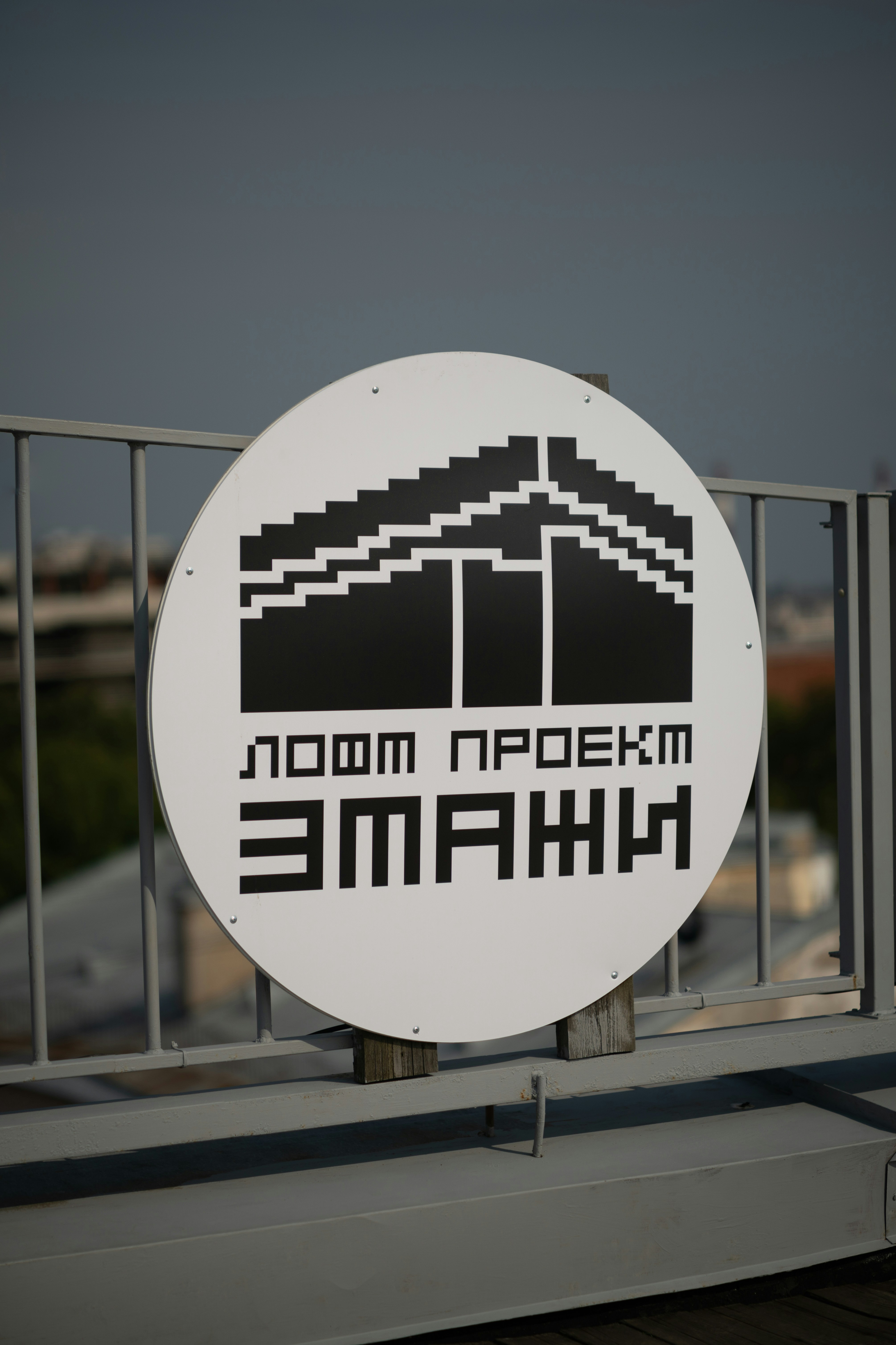 A white and black sign on a metal fence